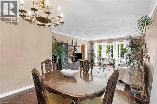 Dining area featuring a prominent chandelier, crown molding, and wood-finish flooring - 1083 Melton Drive, Mississauga, ON 