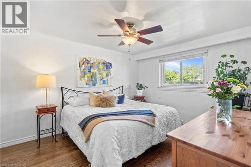 Bright room featuring wood-finish flooring, a ceiling fan, a large window, and white walls - 1083 Melton Drive, Mississauga, ON 