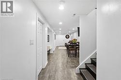 Spacious hallway featuring wood-finish flooring extending through to an open-concept living area - 