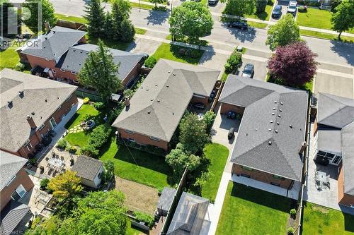 Aerial view showcasing an L-shaped brick residence with a dark shingle roof, a paved driveway, and established front and rear landscaping - 1083 Melton Drive, Mississauga, ON 
