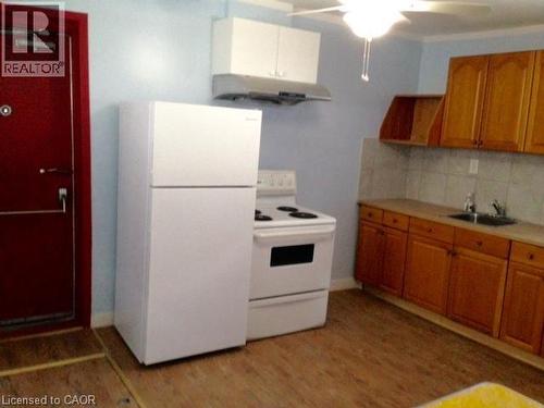 Kitchen featuring wood-finish flooring, light blue walls, and a white ceiling fan - 269 Cannon Street E, Hamilton, ON 