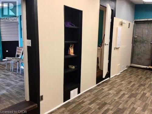 Recessed shelving with a dark finish, wood-finish flooring, light-toned walls, and a white baseboard - 269 Cannon Street E, Hamilton, ON 