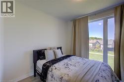 Bright room featuring light-toned walls, wood-finish flooring, and a large window - 