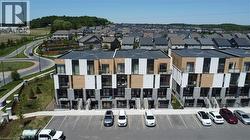 Modern townhome exteriors featuring multi-toned paneling, dark framed windows, and individual balconies - 