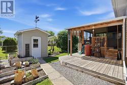 Backyard with shed, garden area & covered porch. - 