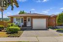 Brick exterior residence featuring a front yard with mature landscaping, a paved driveway, and an attached garage with a white panel door - 102 Juniper Drive, Hamilton, ON 
