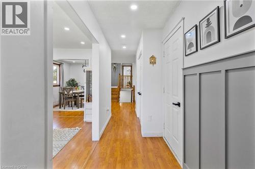 Bright hallway featuring wood-finish flooring, recessed lighting, and a board-and-batten accent wall - 102 Juniper Drive, Hamilton, ON 