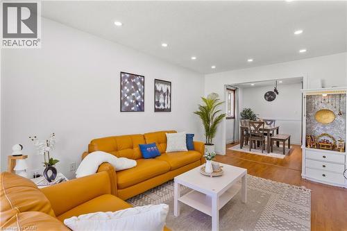 Open-concept living area featuring recessed lighting, light wood-finish flooring, and a defined dining space beyond - 102 Juniper Drive, Hamilton, ON 
