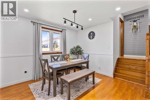 Spacious interior room featuring wood-finish flooring, white walls with wainscoting, and recessed lighting - 102 Juniper Drive, Hamilton, ON 
