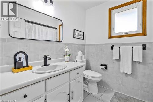 Bathroom featuring a white vanity with integrated sink, matte black faucet, and a large rectangular mirror - 102 Juniper Drive, Hamilton, ON 