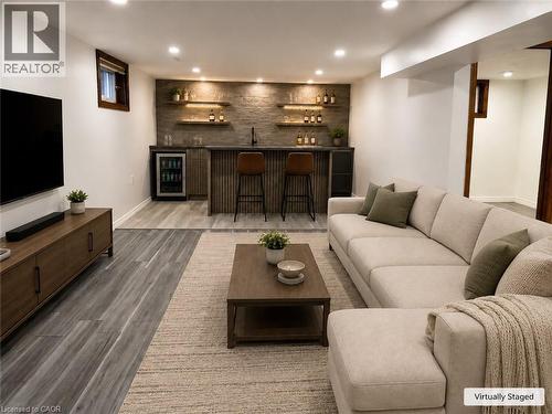 Recreation room featuring a built-in wet bar with a beverage cooler, floating wood shelves, recessed lighting, and wood-finish flooring - 102 Juniper Drive, Hamilton, ON 
