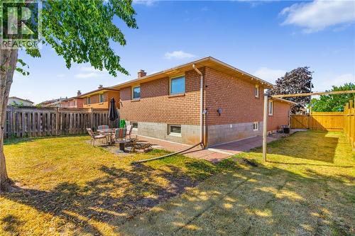 Expansive backyard featuring a brick exterior, block foundation, and mature trees - 102 Juniper Drive, Hamilton, ON 