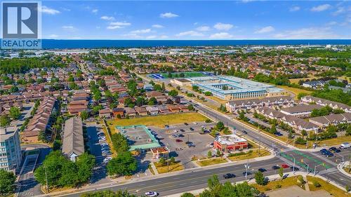 Expansive aerial perspective showcasing a residential area with a prominent institutional building featuring a sports field - 102 Juniper Drive, Hamilton, ON 