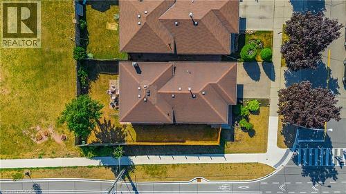 Property featuring a brown shingled roof and a private fenced yard with a paved patio area - 102 Juniper Drive, Hamilton, ON 