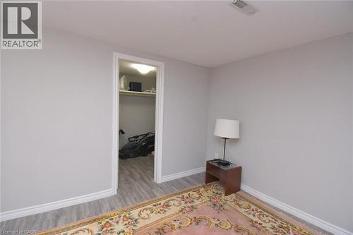 Interior room featuring light gray walls, white trim, and wood-finish flooring - 185 Rosslyn Avenue N, Hamilton, ON 