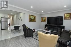 Open-concept living area with crown molding and recessed lighting - 