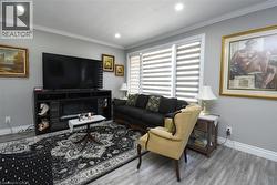 Living area featuring recessed lighting, light gray walls, white crown molding, and wood-finish flooring - 