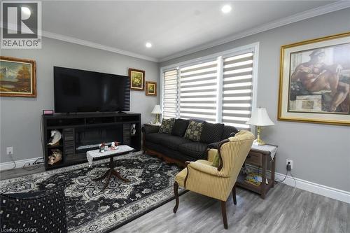 Living area featuring recessed lighting, light gray walls, white crown molding, and wood-finish flooring - 185 Rosslyn Avenue N, Hamilton, ON 