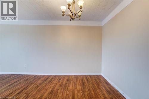 Room featuring wood-finish flooring, neutral wall paint, and white baseboards - 75 Hazelglen Drive Unit# 310, Kitchener, ON 