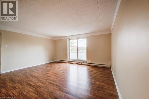 Spacious room featuring wood-finish flooring and a neutral color palette - 75 Hazelglen Drive Unit# 310, Kitchener, ON 