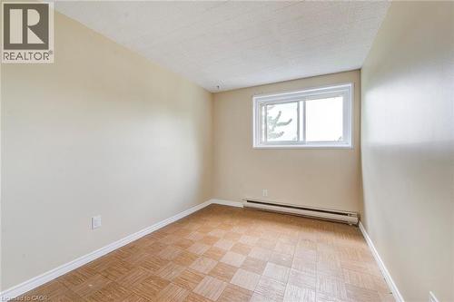 Neutral tone walls with white trim, featuring a horizontal sliding window - 75 Hazelglen Drive Unit# 310, Kitchener, ON 