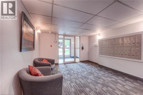 Building entrance featuring glass doors, a patterned carpet, and a wall of mailboxes - 75 Hazelglen Drive Unit# 310, Kitchener, ON 
