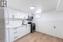 Kitchen featuring white cabinetry with matte black hardware, white countertops, a stainless steel range, and a coordinating microwave - 65 Garden Crescent Unit# Lower, Hamilton, ON  - Indoor Photo Showing Kitchen 