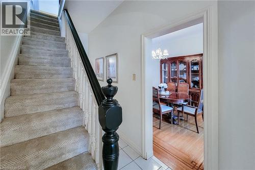 Staircase with carpeted treads and a dark wood newel post - 244 Hughson Street N, Hamilton, ON 