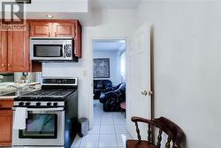 Kitchen featuring wood-finish cabinetry, stainless steel microwave, and stainless steel range - 