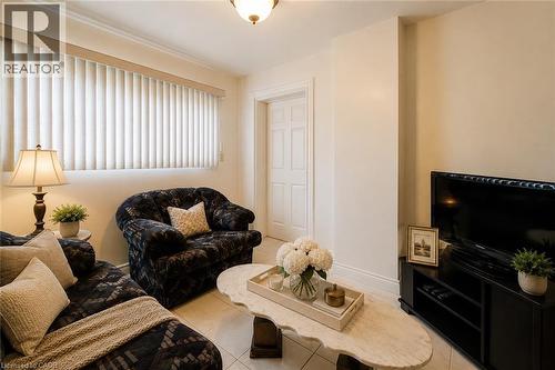 Living area featuring light-toned walls, tile flooring, and a paneled interior door - 244 Hughson Street N, Hamilton, ON 