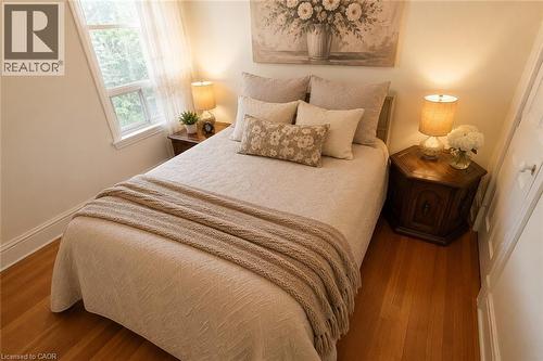 Room featuring wood-finish flooring, a double-hung window, and white trim - 244 Hughson Street N, Hamilton, ON 