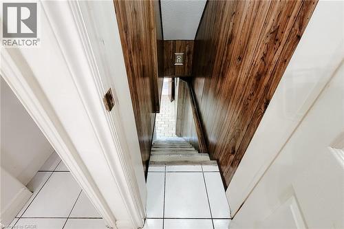 Stairwell with wood-finish wall paneling and white trim - 244 Hughson Street N, Hamilton, ON 