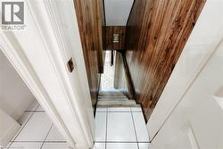 Stairwell with wood-finish wall paneling and white trim - 