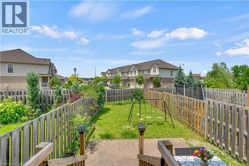Fenced backyard featuring a manicured lawn, established landscaping, and a concrete patio - 48 Clough Crescent, Guelph, ON 