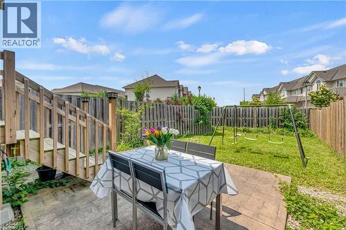 Private backyard featuring a concrete patio area, wooden privacy fencing, and a wooden deck with stairs - 48 Clough Crescent, Guelph, ON 