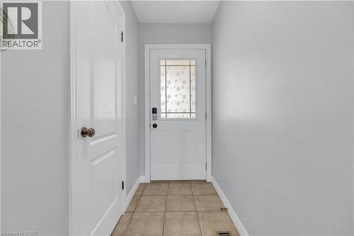 Entryway featuring light neutral wall paint, white trim, and a white paneled door with a decorative glass insert - 48 Clough Crescent, Guelph, ON 
