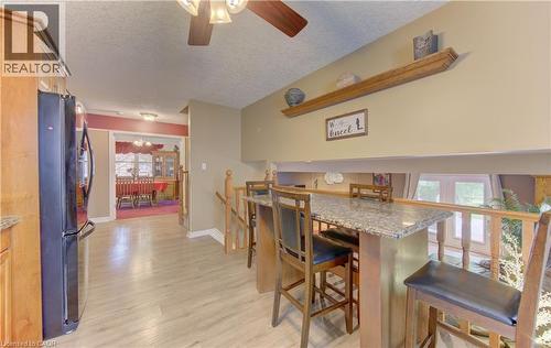 Kitchen with wood-finish flooring, light wood cabinetry, and a black refrigerator - 599 Coldstream Drive, Waterloo, ON 