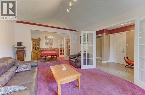 Carpeted living area with a vaulted ceiling and track lighting - 599 Coldstream Drive, Waterloo, ON 