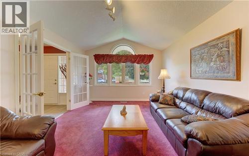 Vaulted ceiling living area featuring a large arched window, multiple window panels, and French doors - 599 Coldstream Drive, Waterloo, ON 