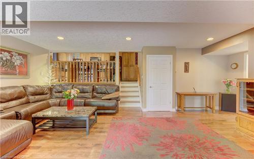 Spacious room featuring wood-finish flooring, recessed lighting, and a neutral color palette - 599 Coldstream Drive, Waterloo, ON 