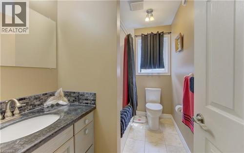 Bathroom featuring a vanity with an integrated sink, a dark countertop, and a tiled backsplash - 599 Coldstream Drive, Waterloo, ON 