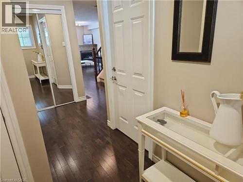 Dark wood-finish flooring extending through the entry hall and into the living area - 596 Spinnaker Crescent, Waterloo, ON 