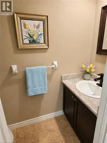 Vanity with a white oval sink, dark cabinetry, and speckled countertop - 596 Spinnaker Crescent, Waterloo, ON 
