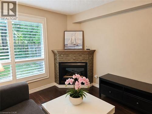 Corner fireplace with stone-finish surround and traditional wood mantel - 596 Spinnaker Crescent, Waterloo, ON 