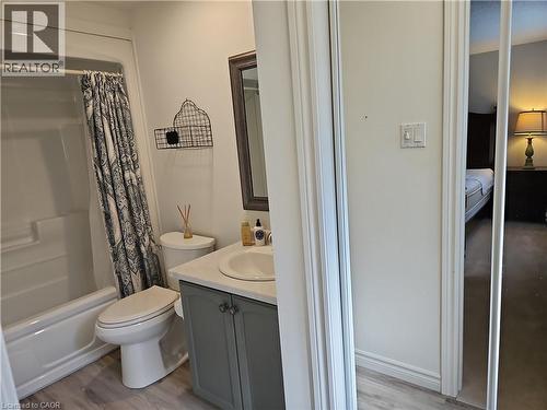 Bathroom featuring a white bathtub and shower combination, a toilet, and a vanity with a white countertop and gray cabinetry - 596 Spinnaker Crescent, Waterloo, ON 