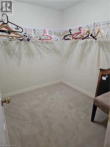 Spacious walk-in closet featuring wire shelving, wall-to-wall carpeting, and neutral wall tones - 596 Spinnaker Crescent, Waterloo, ON 