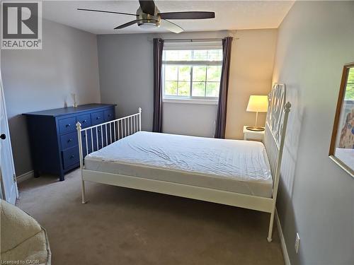 Carpeted room featuring a window with natural light, a ceiling fan with integrated lighting, and neutral wall tones - 596 Spinnaker Crescent, Waterloo, ON 