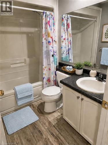 Functional bathroom featuring a white tub-shower combination, a white toilet, and a vanity with white cabinetry and a dark countertop - 596 Spinnaker Crescent, Waterloo, ON 
