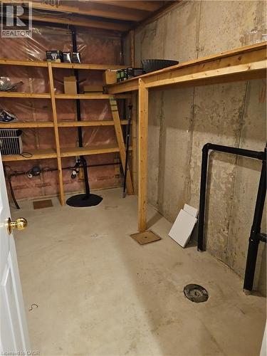 Unfinished basement space featuring concrete flooring, exposed wooden framing, and integrated shelving - 596 Spinnaker Crescent, Waterloo, ON 