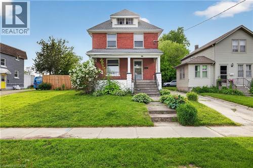 Red brick exterior with white trim, a covered front porch, and a dormer window - 26 Arthur Avenue, St. Thomas, ON - Outdoor With Facade